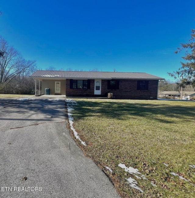 ranch-style house featuring a front lawn and a carport