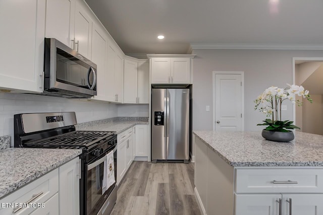 kitchen featuring light stone counters, stainless steel appliances, crown molding, white cabinets, and light hardwood / wood-style floors