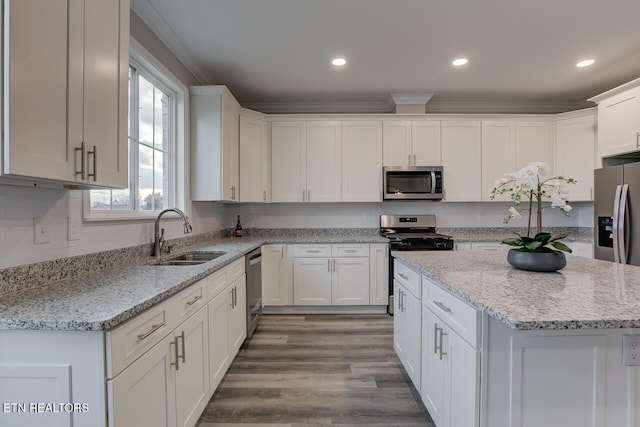 kitchen featuring sink, stainless steel appliances, light stone counters, white cabinets, and light wood-type flooring