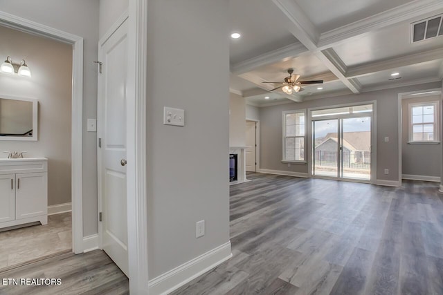 unfurnished living room featuring beam ceiling, ceiling fan, coffered ceiling, and hardwood / wood-style flooring