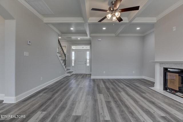 unfurnished living room with beamed ceiling, crown molding, a high end fireplace, and coffered ceiling