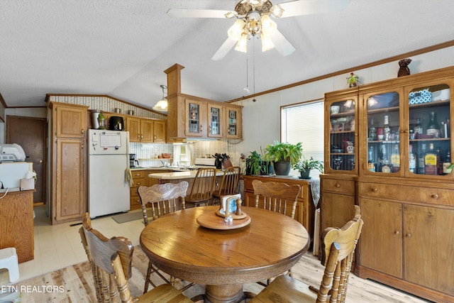 dining area with ceiling fan, crown molding, and vaulted ceiling