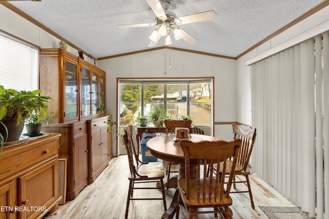 dining area with ceiling fan, vaulted ceiling, ornamental molding, and light hardwood / wood-style flooring