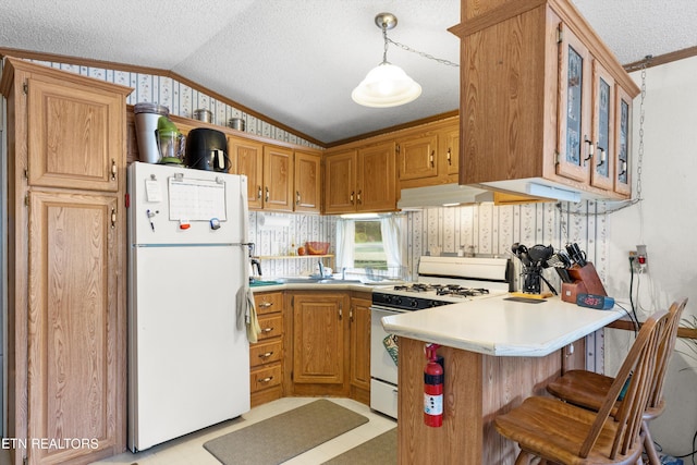 kitchen featuring pendant lighting, white appliances, sink, vaulted ceiling, and kitchen peninsula