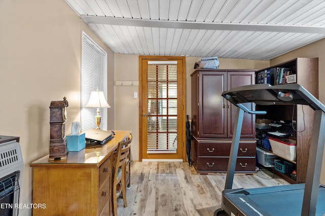 exercise room with heating unit and light hardwood / wood-style flooring