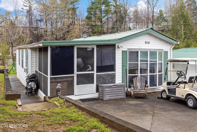 rear view of house featuring a patio area and a sunroom