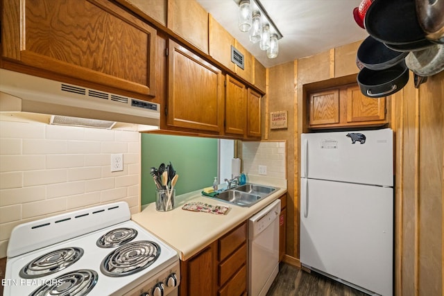 kitchen with tasteful backsplash, sink, dark hardwood / wood-style floors, and white appliances