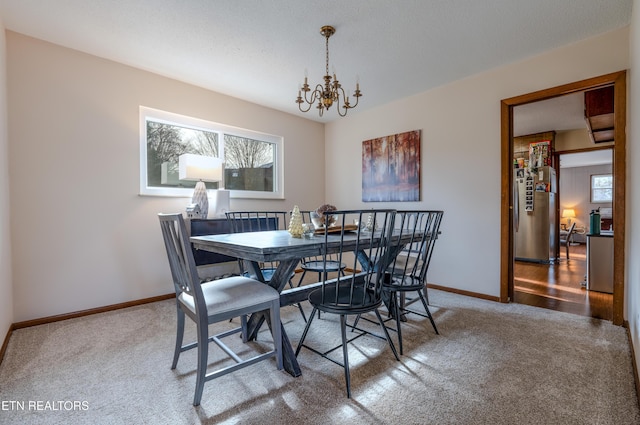 dining area featuring carpet and a chandelier