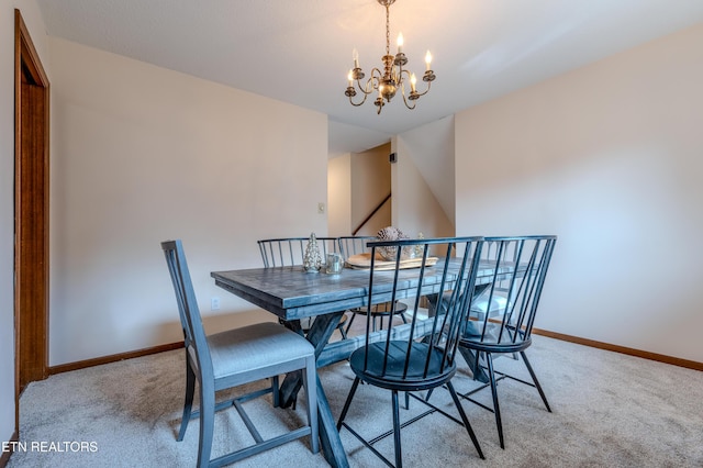 carpeted dining room with a chandelier