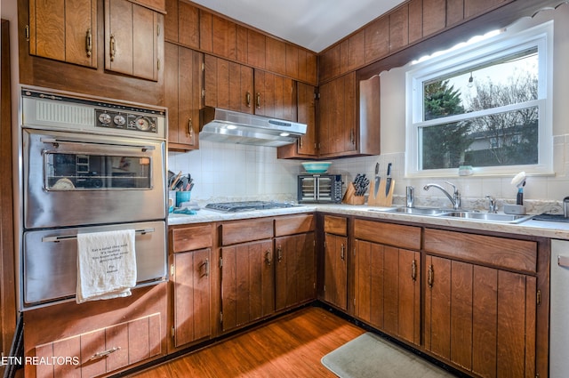 kitchen with backsplash, dark hardwood / wood-style flooring, sink, and stainless steel appliances