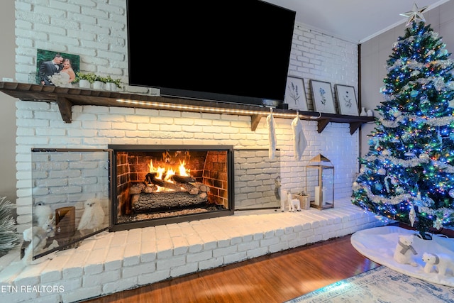 details with crown molding, hardwood / wood-style floors, and a brick fireplace