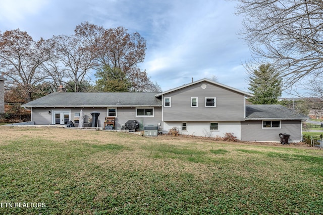 back of property with central AC, a patio area, and a lawn