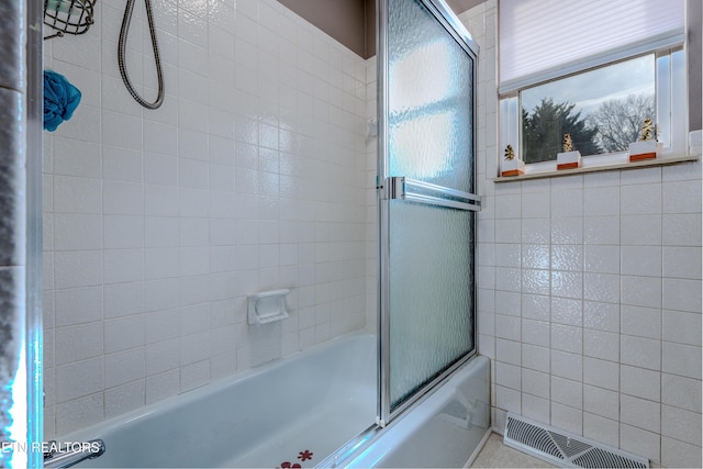 bathroom with combined bath / shower with glass door