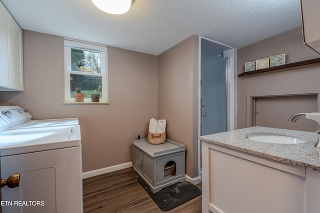 washroom featuring washer and clothes dryer, dark hardwood / wood-style flooring, sink, and a textured ceiling