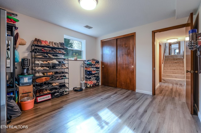 unfurnished bedroom with a textured ceiling, light hardwood / wood-style flooring, and a closet