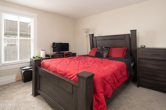 bedroom featuring light carpet and baseboards