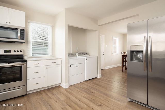 kitchen with independent washer and dryer, light wood-type flooring, stainless steel appliances, and white cabinetry