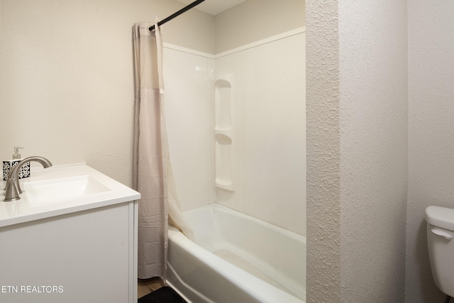 full bath with shower / bath combo, a textured wall, vanity, and toilet