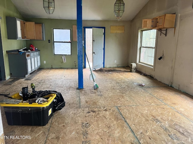 kitchen with pendant lighting, a healthy amount of sunlight, and vaulted ceiling