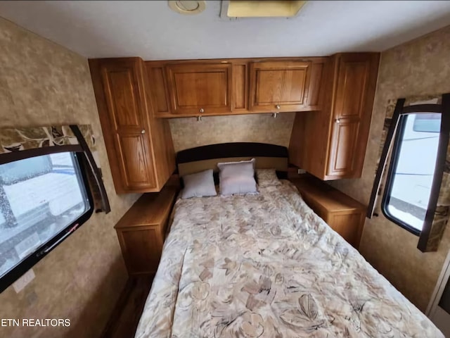 bedroom with multiple windows and a fireplace