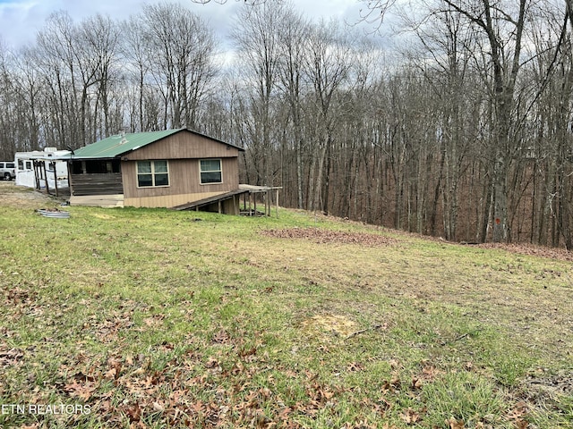 view of home's exterior featuring a view of trees and a lawn