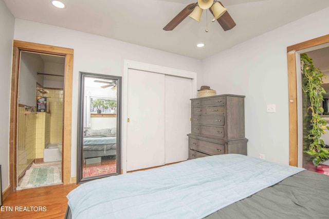 bedroom featuring hardwood / wood-style floors, ceiling fan, and ensuite bath