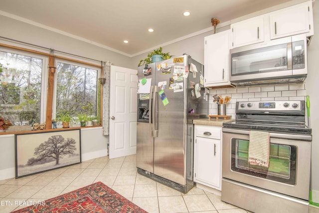 kitchen featuring stainless steel appliances, white cabinetry, crown molding, and light tile patterned flooring