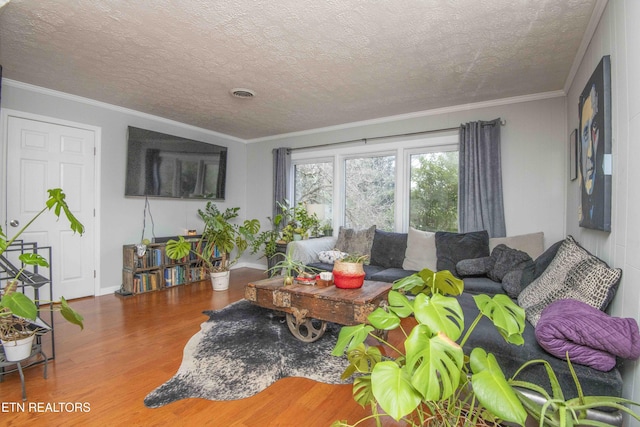 living room featuring ornamental molding, a textured ceiling, and hardwood / wood-style flooring