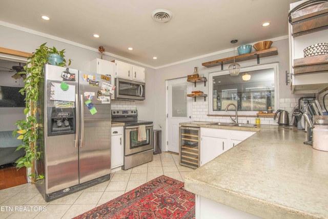 kitchen featuring crown molding, sink, white cabinetry, stainless steel appliances, and beverage cooler