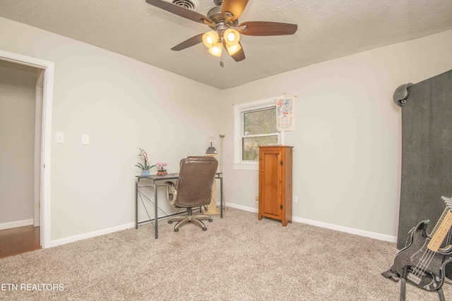 carpeted office featuring ceiling fan and a textured ceiling