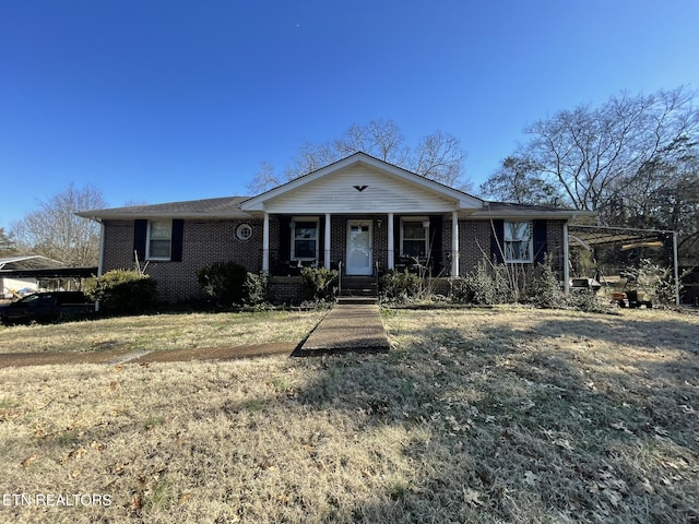 ranch-style house featuring a porch, a carport, and a front lawn