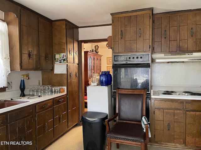 kitchen with dark brown cabinetry, ornamental molding, black double oven, and white electric stovetop