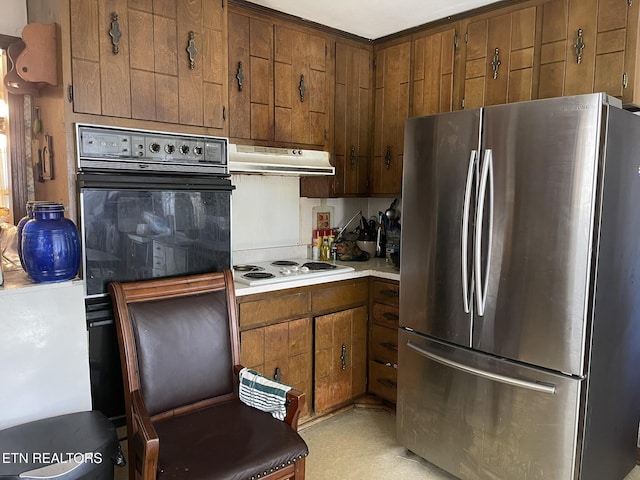 kitchen featuring white stovetop, stainless steel fridge, and oven