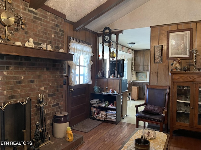 living room featuring lofted ceiling with beams, dark hardwood / wood-style floors, a textured ceiling, and wooden walls