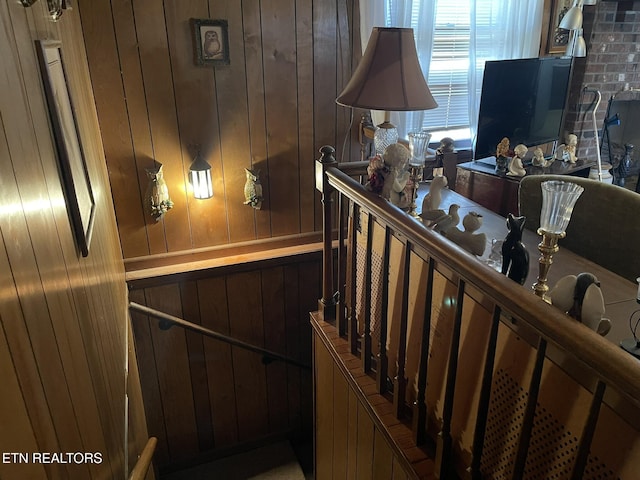 stairs featuring wood walls