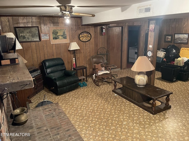 living room with ceiling fan and wood walls