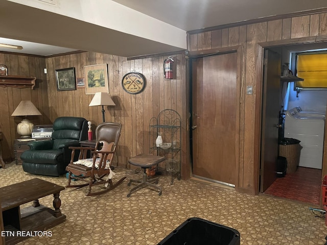 sitting room featuring washer and dryer and wood walls