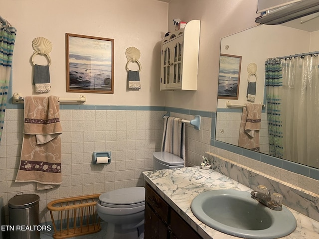 bathroom featuring a shower with curtain, vanity, tile walls, and toilet