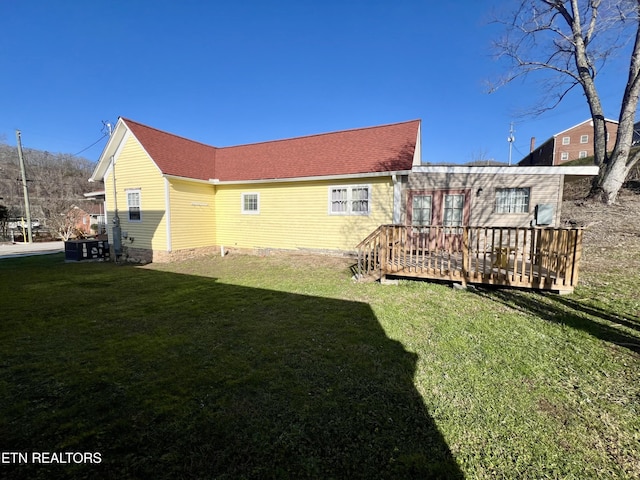 rear view of house featuring a yard and a wooden deck