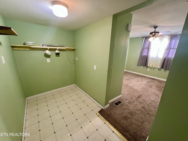 clothes washing area featuring a textured ceiling and ceiling fan