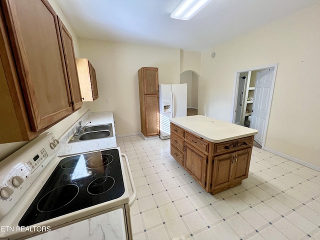 kitchen featuring a kitchen island, white appliances, and sink