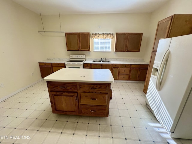 kitchen featuring white appliances, a center island, and sink