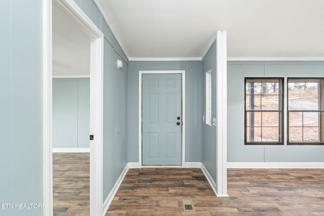 entrance foyer featuring dark wood-type flooring and ornamental molding