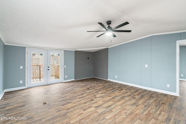 interior space featuring lofted ceiling, french doors, ceiling fan, wood-type flooring, and brick wall