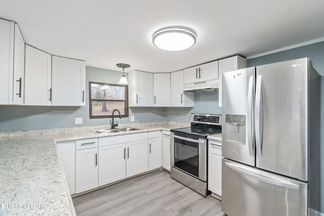 kitchen featuring appliances with stainless steel finishes, sink, pendant lighting, light hardwood / wood-style floors, and white cabinetry