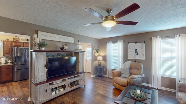 living room featuring dark wood-type flooring, a textured ceiling, and ceiling fan