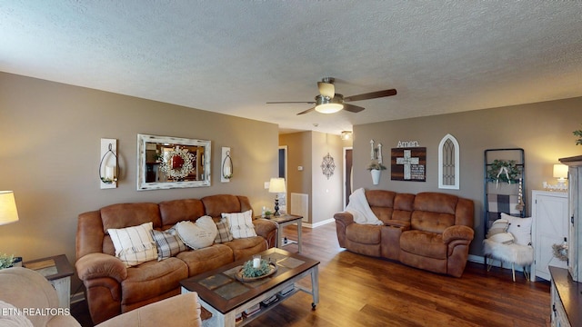 living room featuring ceiling fan, dark hardwood / wood-style floors, and a textured ceiling