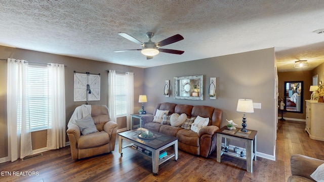 living room featuring dark hardwood / wood-style floors, a textured ceiling, and ceiling fan