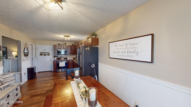 dining space featuring dark wood-type flooring and a textured ceiling