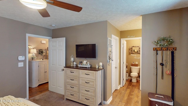 bedroom with ceiling fan, a textured ceiling, and light hardwood / wood-style floors